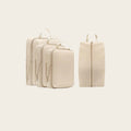 Ordvik Packwürfel-Set in Beige: drei Packwürfel in gestaffelten Größen und ein separater Schuhbeutel